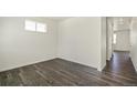 Bright, vacant room featuring sleek hardwood flooring, a window, and neutral white walls at 837 Ledge St, Lochbuie, CO 80603