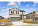 Two-story home with stone accents, gray siding, a two car garage, and a well-maintained lawn at 837 Ledge St, Lochbuie, CO 80603