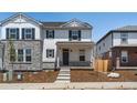 Charming two-story home with stone accents, black shutters, and inviting front porch at 22495 E 7Th Pl, Aurora, CO 80018