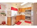 Bright kitchen with stainless steel appliances, light wood cabinets, and tile countertops at 6126 S Pierson St, Littleton, CO 80127