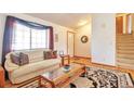 Cozy living room with a comfortable sofa, hardwood floors, and staircase access at 6126 S Pierson St, Littleton, CO 80127