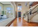 Grand foyer featuring soaring ceilings, hardwood floors, and a staircase with iron railings at 7408 Sodalite Way, Castle Rock, CO 80108