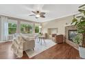 Bright living room featuring hardwood floors, a stone fireplace, and large windows overlooking the yard at 123 Wheat Ridge St, Palmer Lake, CO 80133