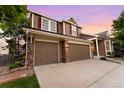 Exterior of a two-story home featuring a two-car garage and brick accents at 23060 Hope Dale Ave, Parker, CO 80138