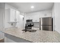 Updated kitchen with granite countertops, stainless steel appliances, and white cabinetry at 14720 E Kentucky Dr # 612, Aurora, CO 80012