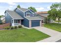 Charming two-story home with blue siding, a well-manicured lawn, and an attached two-car garage at 5124 S Jebel St, Centennial, CO 80015