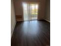 Bright living room with sliding glass doors and dark wood-look floors provides lots of natural light at 665 S Clinton St # 14A, Denver, CO 80247