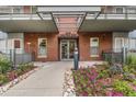 Building entrance with brick facade, decorative flowers, and well-maintained landscaping at 1440 Little Raven St # 202, Denver, CO 80202