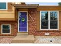 Close-up of the home's entry, featuring a vibrant door and attractive brickwork at 18130 E Asbury Dr, Aurora, CO 80013