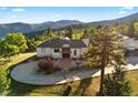 A beautiful home with a circular driveway, landscaping, and mountain views at 12291 S Critchell Ln, Littleton, CO 80127