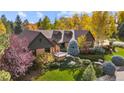 Beautiful front exterior with brick accents, manicured landscaping, and mature trees in a serene setting at 11 E Belleview Ln, Greenwood Village, CO 80121