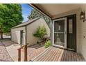 Inviting front porch with a screen door and green trim next to a detached garage at 6414 S Hudson St, Centennial, CO 80121