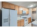 Well-equipped kitchen features white appliances, wood cabinets, and a range oven at 2225 Buchtel Blvd # 1003, Denver, CO 80210