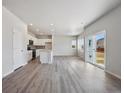 Bright living area featuring sleek flooring, large windows, and an open layout at 2162 Flower Blossom Ave, Brighton, CO 80601