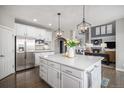 Modern kitchen with a large island, stainless steel appliances, and an open view to the living area at 26989 E Friend Pl, Aurora, CO 80016