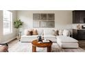 Comfortable living room with a white sectional sofa, wood coffee table, and stylish decorations at 6307 Dayton Ct, Denver, CO 80238