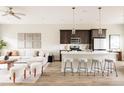 Open-concept living room and kitchen featuring a stylish island, modern furniture, and hardwood floors at 6307 Dayton Ct, Denver, CO 80238