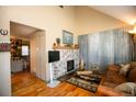 Inviting living room with wood floors, stone fireplace, and rustic metal wall accent at 7978 Chase Cir # G, Arvada, CO 80003