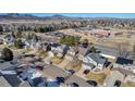 Aerial view of neighborhood with houses, school, and mountains at 12047 W Coal Mine Dr, Littleton, CO 80127