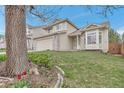 Attractive two-story home featuring a well-manicured lawn, a stone-accented facade, and a welcoming entrance at 12047 W Coal Mine Dr, Littleton, CO 80127