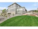 Wide-open backyard with pristine lawn space, complimented by rock accents, plants, and a charming fence at 27986 E Frost Pl, Aurora, CO 80016