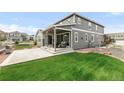 Lovely home showcasing a spacious backyard, lush green lawn, a covered patio, and a gray exterior at 27986 E Frost Pl, Aurora, CO 80016