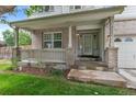 Close-up of the front porch of a brick home, showcasing a cozy seating area and decorative columns at 7171 Canyon Way, Frederick, CO 80504
