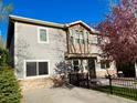 Charming two-story home with a well-maintained front yard and mature landscaping, set against a clear blue sky at 2525 S Pennsylvania St, Denver, CO 80210