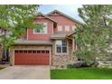 Charming two-story home with a stone and red siding exterior and an attached two-car garage at 24686 E Florida Ave, Aurora, CO 80018