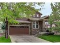 Charming two-story home with brown siding, stone accents, and a two-car garage at 24686 E Florida Ave, Aurora, CO 80018