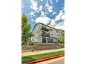 Three-story townhome showcases a modern design with a balcony and well-maintained landscaping at 2108 Alcott Way, Broomfield, CO 80023