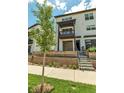 Three-story townhouse featuring a balcony, garage, and tiered landscaping in a residential area at 2108 Alcott Way, Broomfield, CO 80023