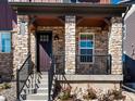 Stone front porch with dark door and metal railing at 8115 Mt Harvard Rd, Littleton, CO 80125