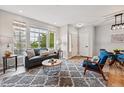 Bright living room with large windows, modern furniture, and a stylish gray patterned rug over vinyl flooring at 5555 E Briarwood Ave # 2604, Centennial, CO 80122