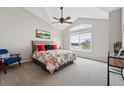 Sunlit bedroom with vaulted ceilings, a ceiling fan, a floral print duvet cover, and neutral gray carpet at 5555 E Briarwood Ave # 2604, Centennial, CO 80122