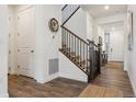 Bright entryway featuring hardwood floors, staircase with wrought iron railing, and a view into other rooms at 3377 S Quartz St, Morrison, CO 80465