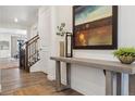 Inviting entryway with hardwood floors, stylish console table, modern decor, and staircase to upper level at 3377 S Quartz St, Morrison, CO 80465