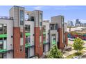 Contemporary townhouse with brick accents, rooftop terrace, and views of the city skyline in the background at 3008 Blake St, Denver, CO 80205