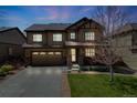 Beautiful home featuring a well-lit exterior, a two-car garage, and a lush front lawn at 12678 Fisher Ln, Englewood, CO 80112