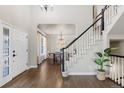 Welcoming foyer with hardwood floors, staircase with black and white railings, and dining room in the background at 7099 Cerney Cir, Castle Pines, CO 80108