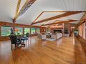 Bright living room with vaulted ceilings, wood floors, and a stone fireplace at 32453 Upper Bear Creek Rd, Evergreen, CO 80439