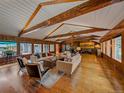 Large living room with wood floors, wood paneled walls, vaulted ceiling, and stone fireplace at 32453 Upper Bear Creek Rd, Evergreen, CO 80439