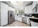 Bright kitchen featuring stainless steel appliances, white cabinets, and a black backsplash at 12663 S Silver Creek Ct, Parker, CO 80134
