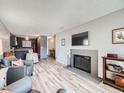 Open concept living room with fireplace, wood floors and kitchen access at 2740 W 86Th Ave # 178, Westminster, CO 80031