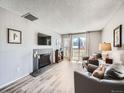 Bright living room with modern fireplace, wood floors, and balcony access at 2740 W 86Th Ave # 178, Westminster, CO 80031