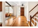 Bright foyer boasts gleaming hardwood floors, staircase, and coat closet adjacent to wood front door at 6385 S Jay Way, Littleton, CO 80123