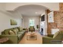 Beautiful living room with exposed brick, modern fireplace, and stylish green furniture at 575 N Marion St, Denver, CO 80218