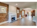 Open-concept living room with exposed brick and a modern fireplace with a kitchen view at 575 N Marion St, Denver, CO 80218