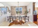 Stylish dining room with brick accent wall, chandelier, and a hide-print rug at 10935 Acadia, Parker, CO 80138