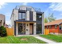 Modern two-story home with white brick, black accents, rooftop deck, and a well-maintained lawn at 357 S Franklin St, Denver, CO 80209